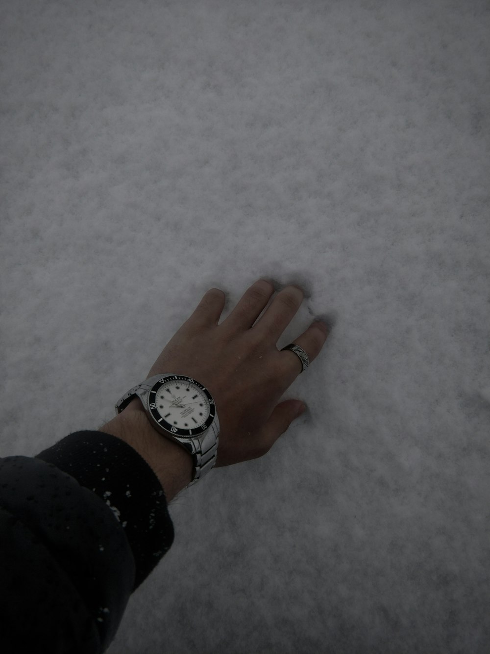 a person with a watch on their wrist standing in the snow