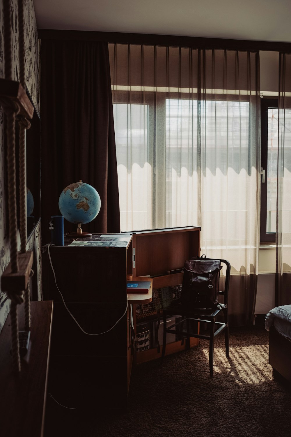 a bedroom with a bed, desk, chair and window