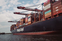 A container ship loaded with carefully packed glass products departing from port.