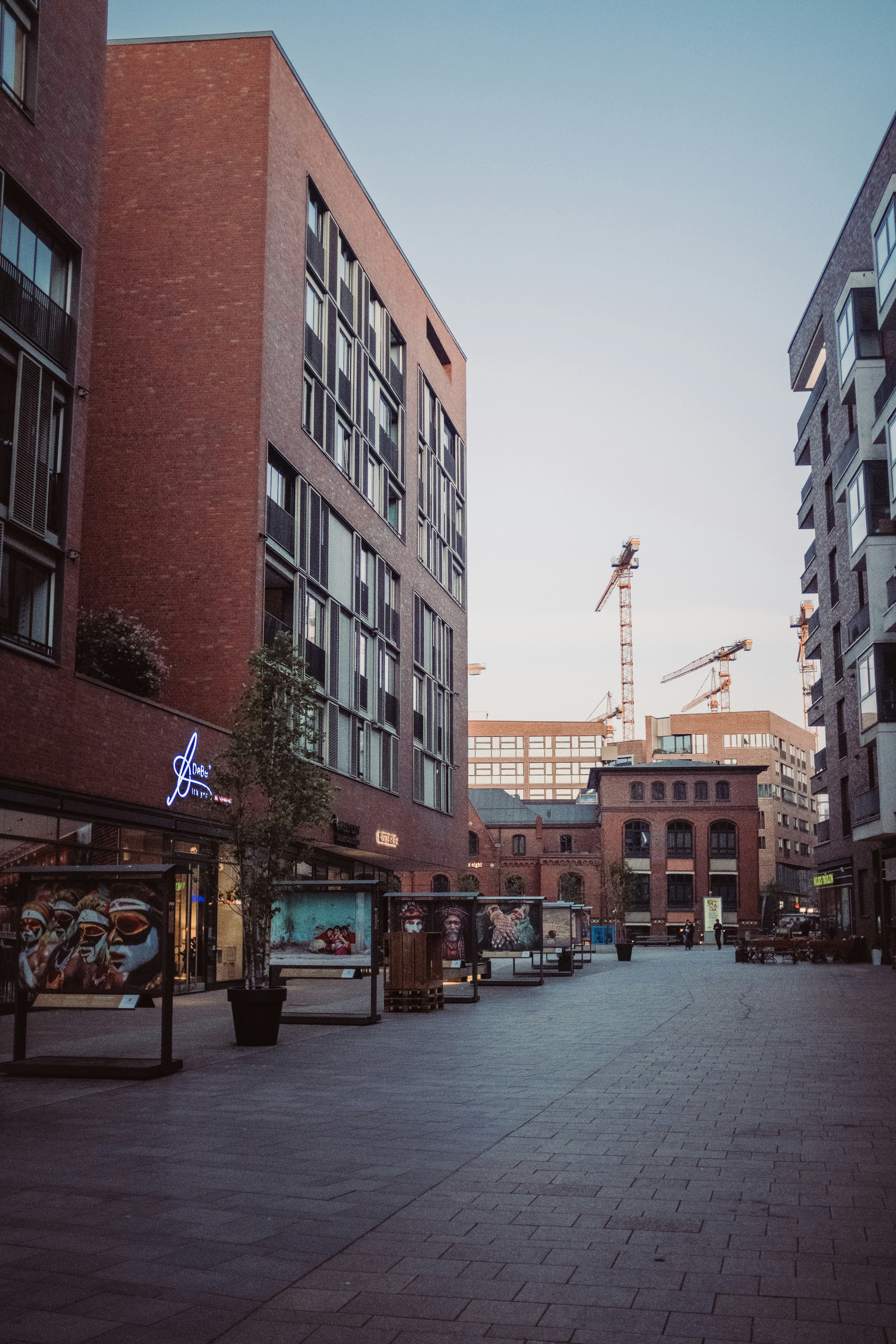 a city street with tall buildings and a crane in the background