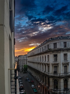 A vibrant sunset over a historic Mexican cityscape with colonial architecture and cobblestone streets