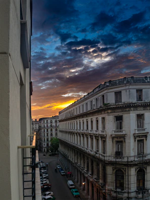 Sunset casting warm hues over a row of preserved historic landmarks, highlighting their architectural details against a soft sky.