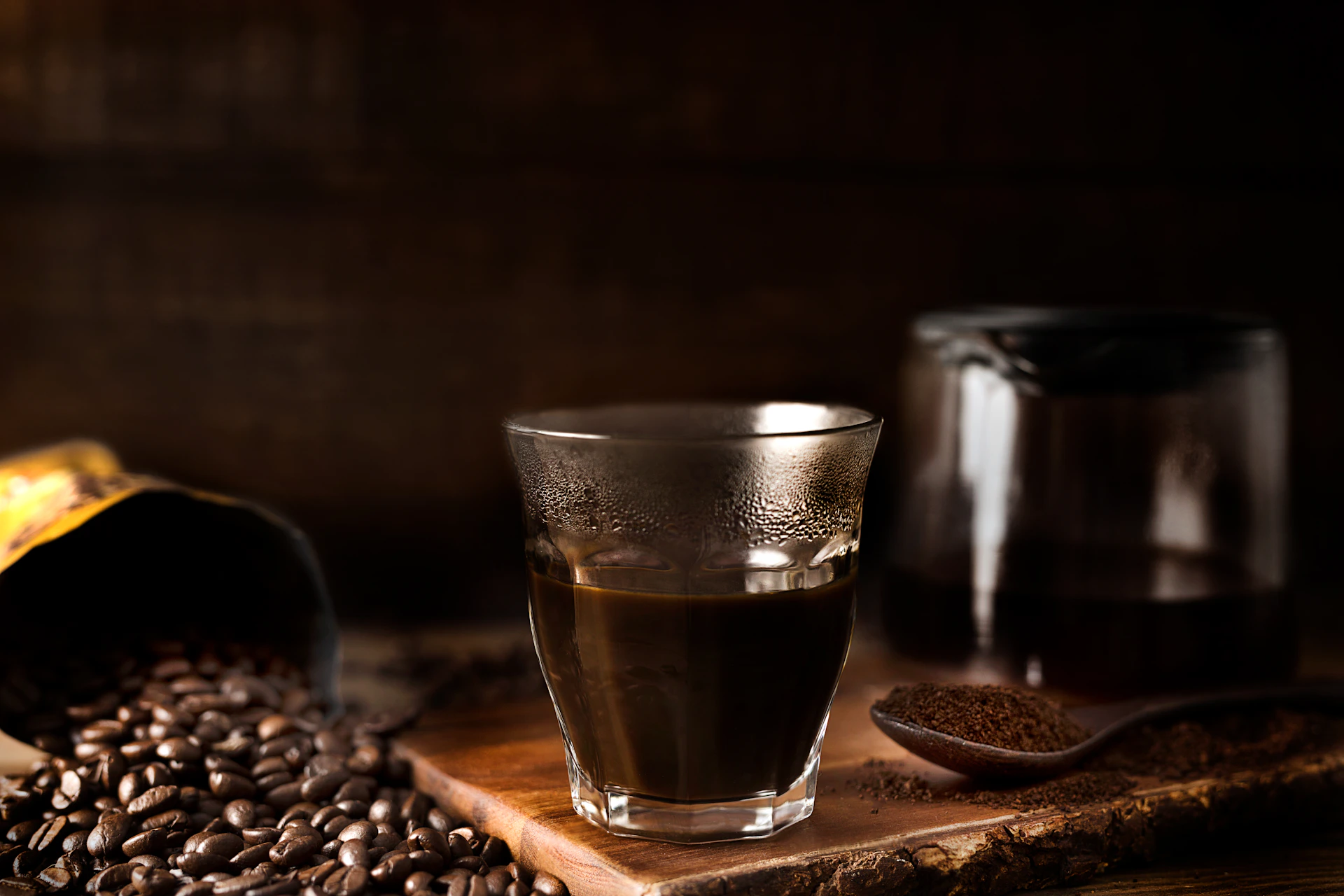 a glass of coffee sitting on top of a wooden table