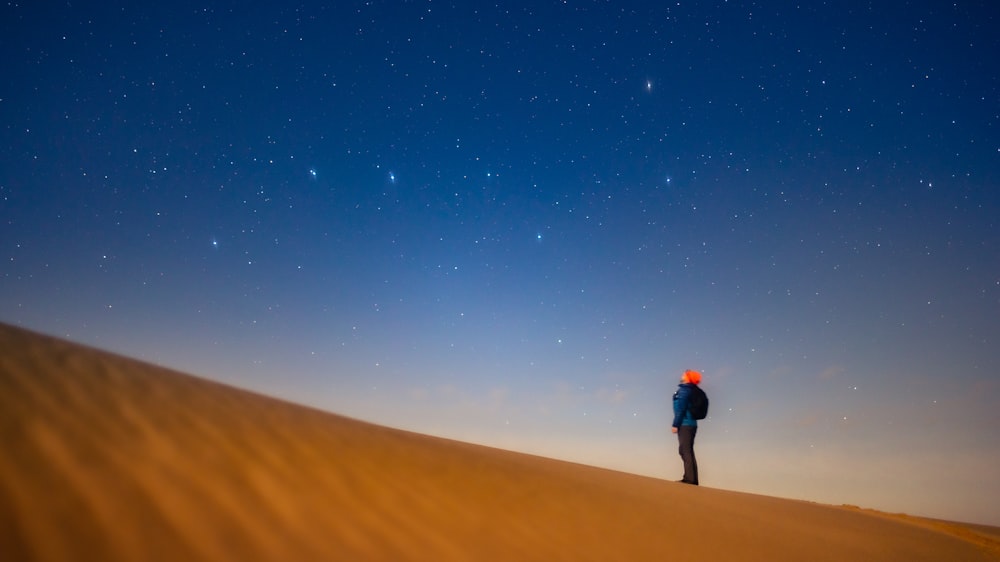 a person standing on top of a sandy hill