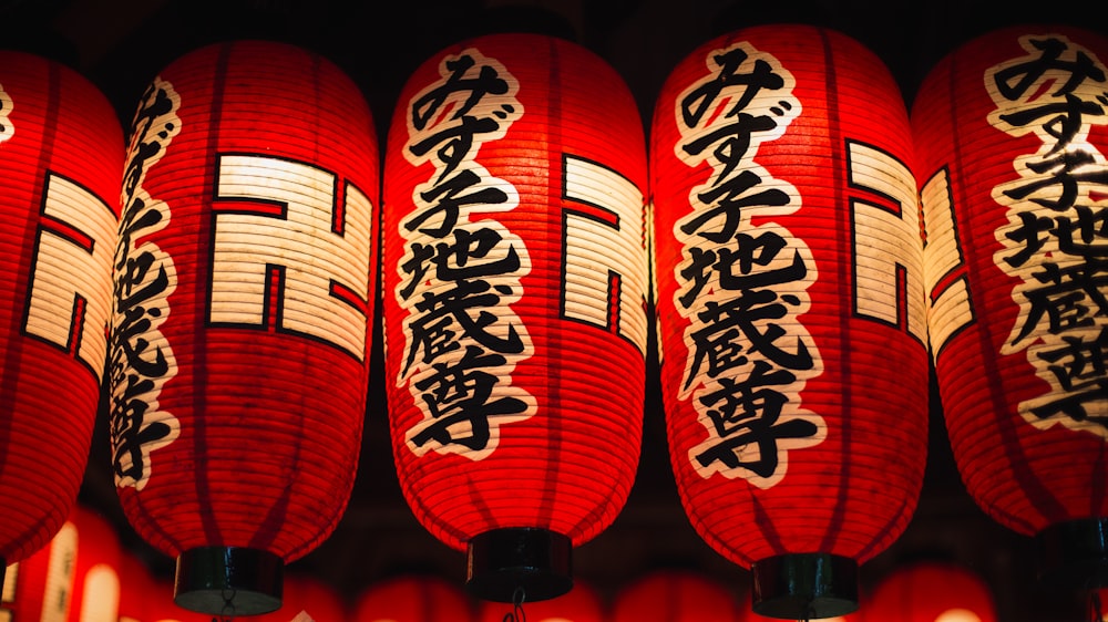 a row of red lanterns with asian writing on them