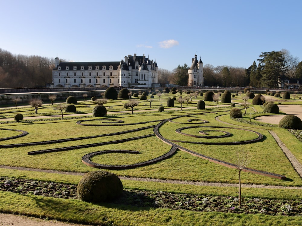 un grand bâtiment avec un jardin en face