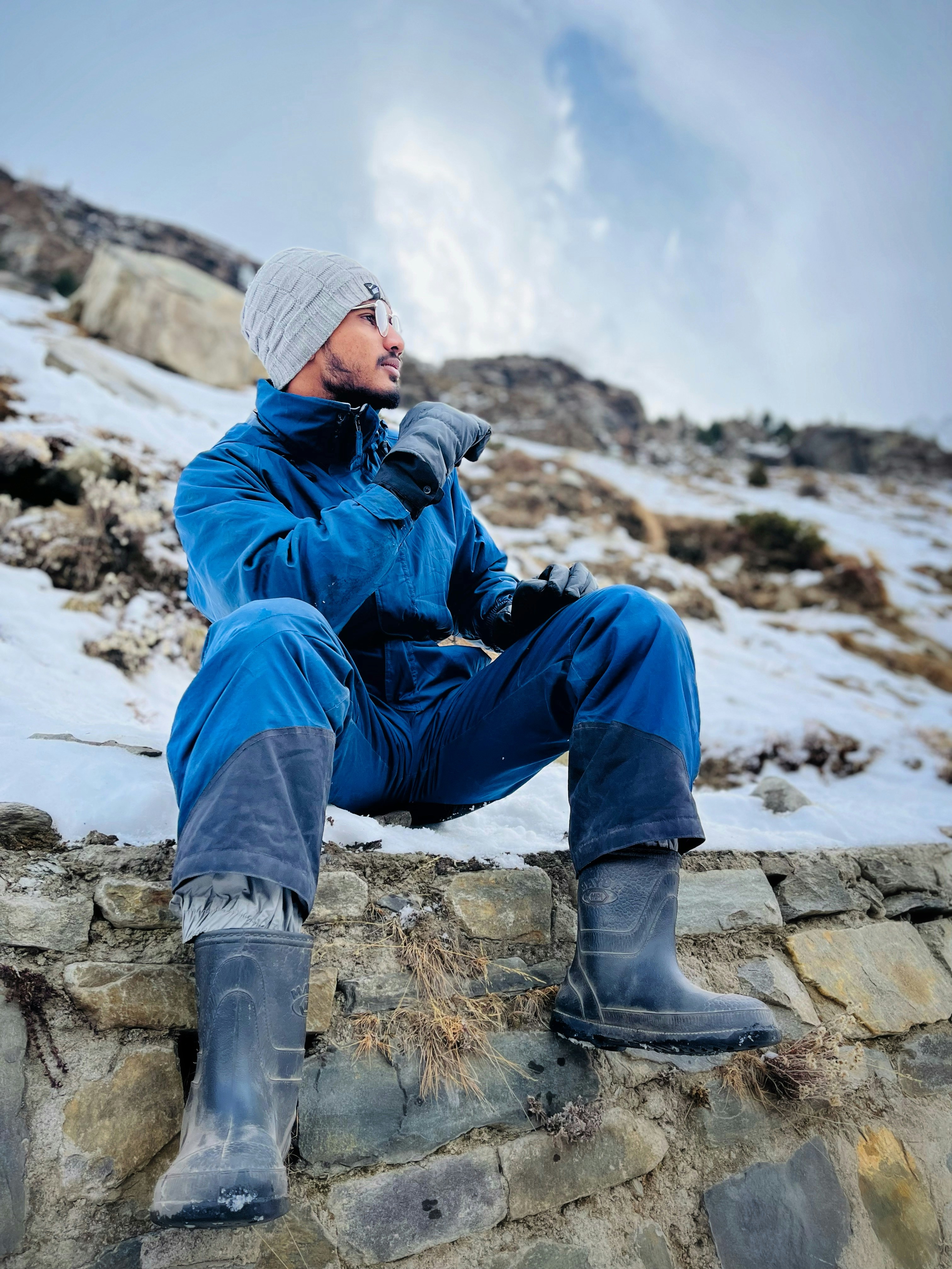 A man sitting on top of a stone wall photo – Free Atal tunnel Image on ...