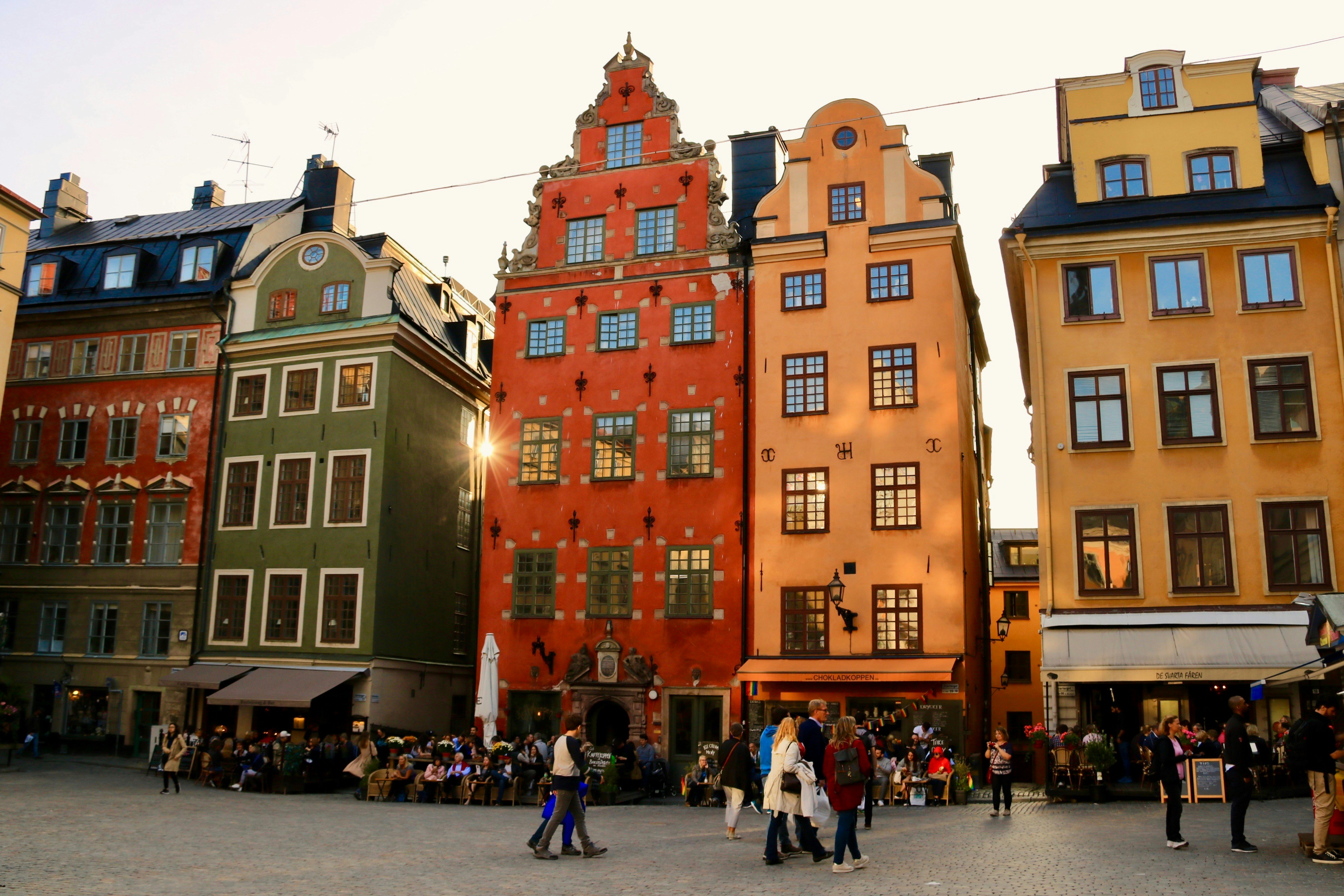 a group of people walking around a street next to tall buildings, Stockholm🇸🇪