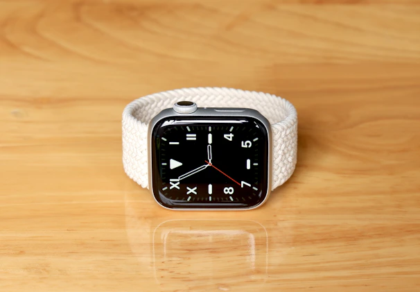 A stylish smartwatch resting on a minimalist white surface, showcasing its vibrant display.