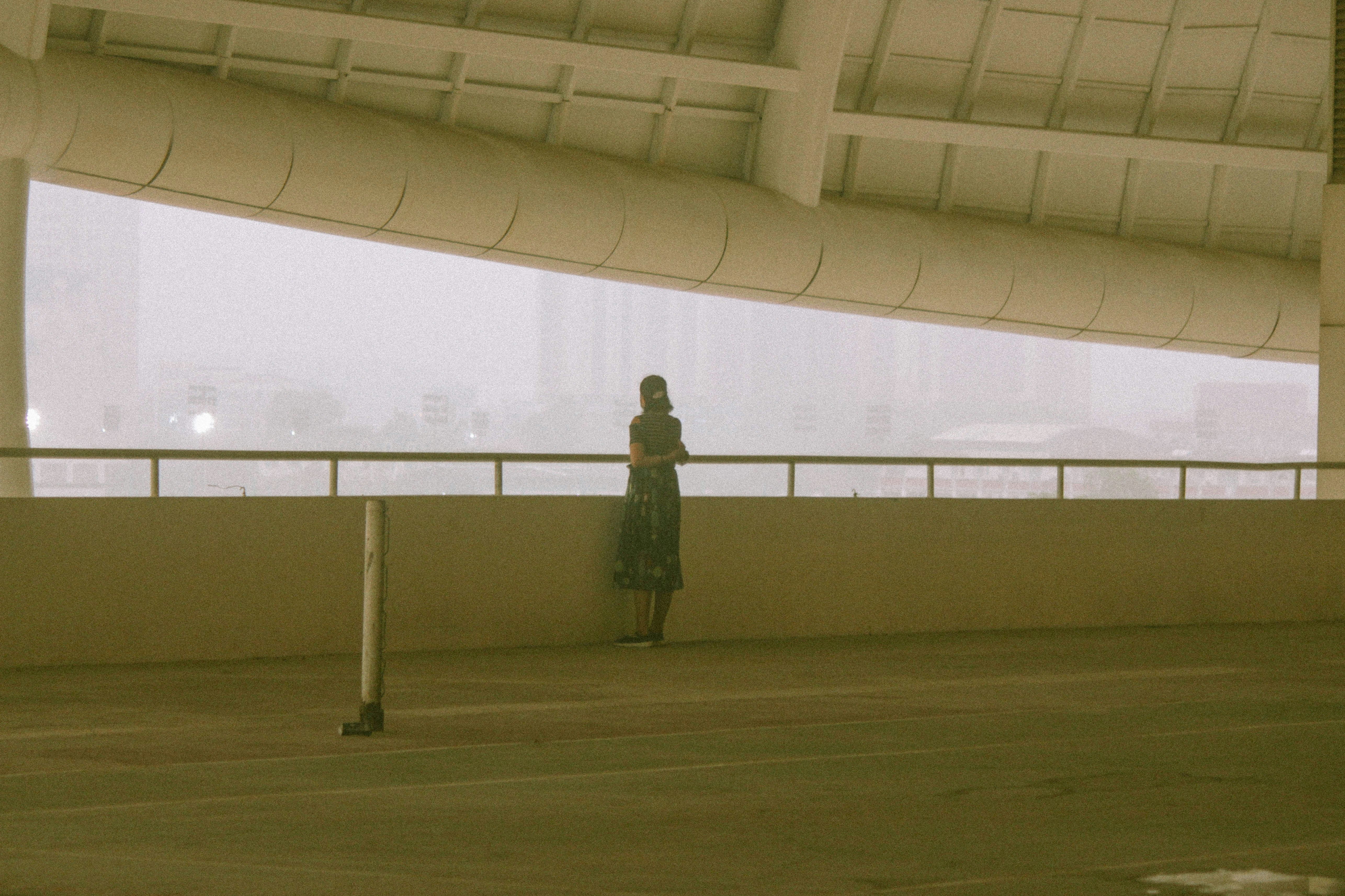 a woman standing on a bridge looking out over the water