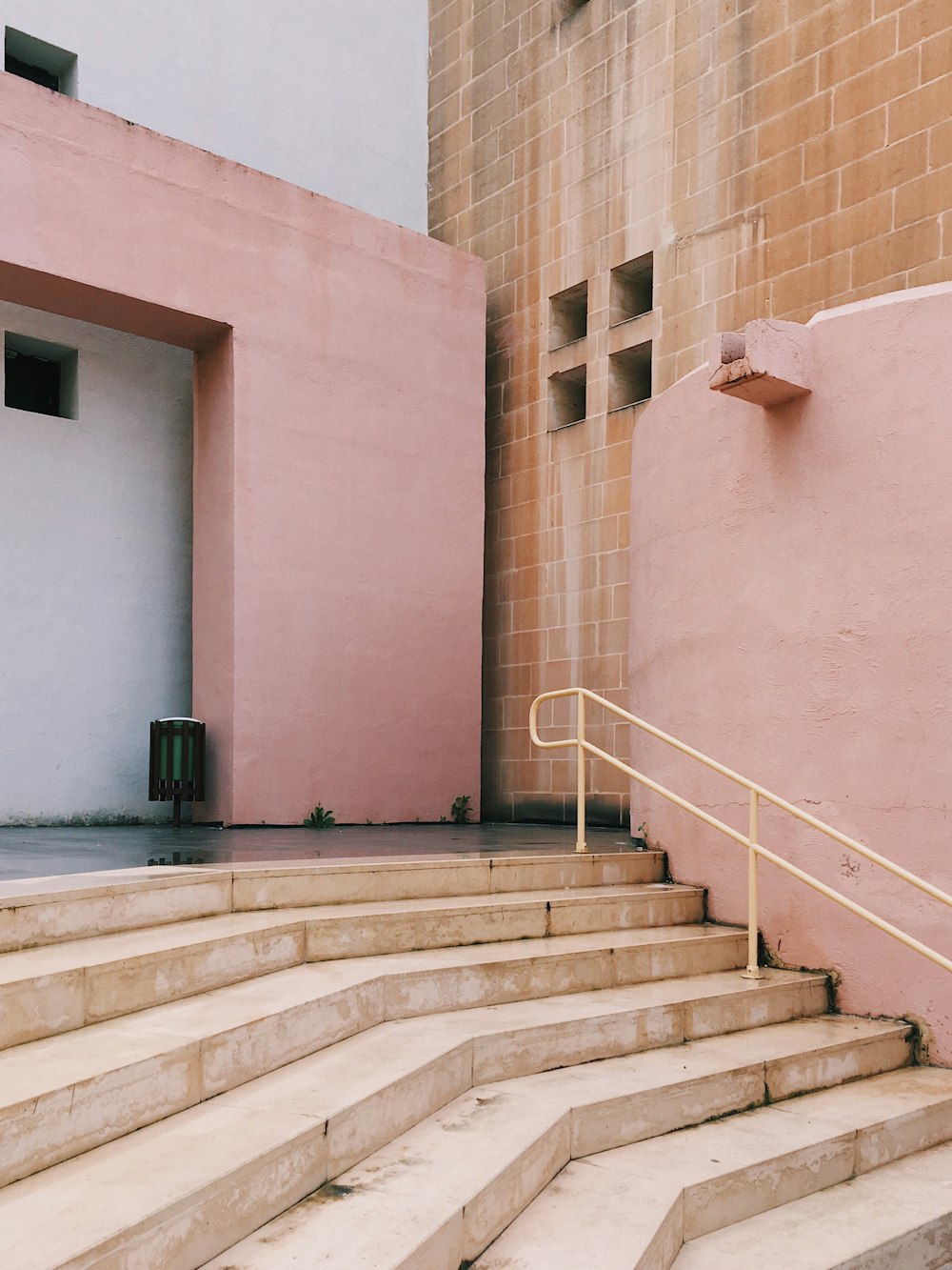 a set of stairs leading up to a pink building