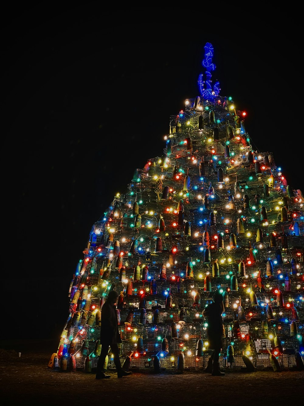 a large christmas tree is lit up at night