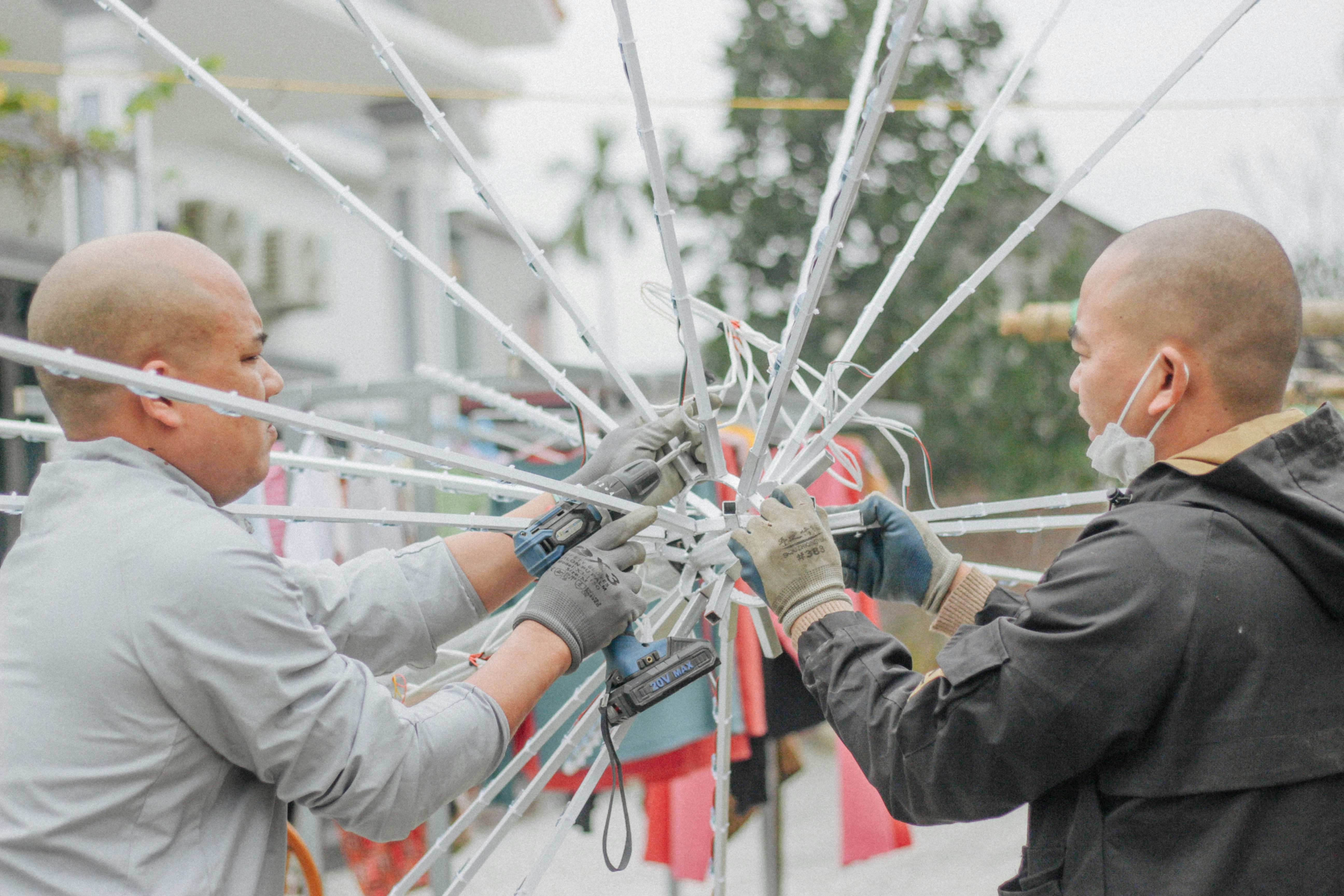 a couple of men working on a metal structure