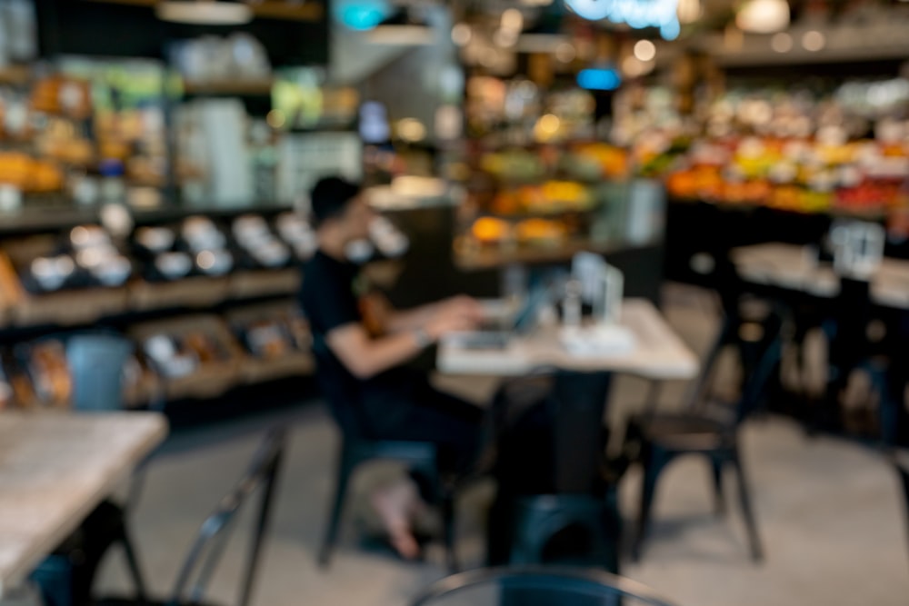 a blurry photo of a restaurant with a person working on a laptop