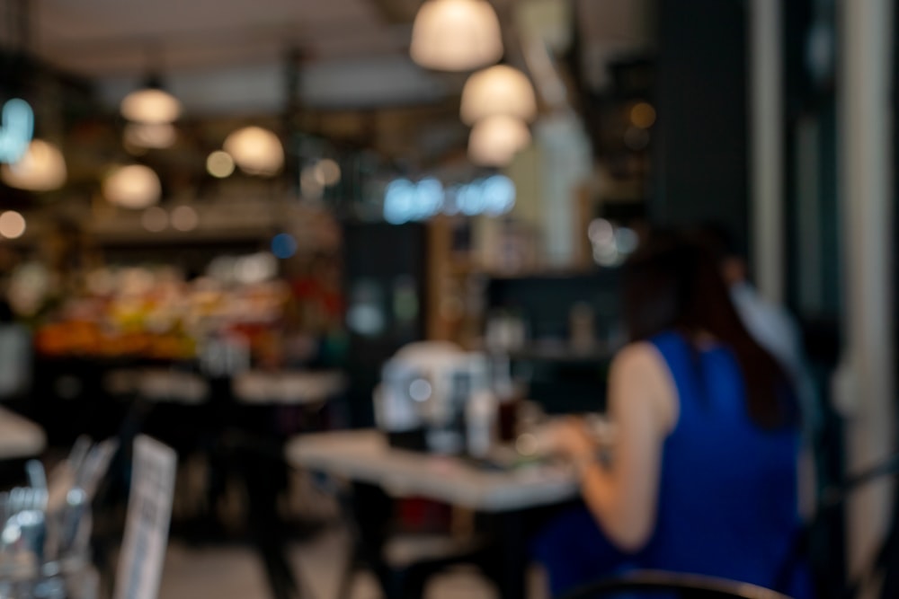 a blurry photo of a woman sitting at a table in a restaurant