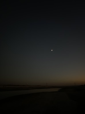 A peaceful moment of reflection with the night sky in deep blue and golden hues.