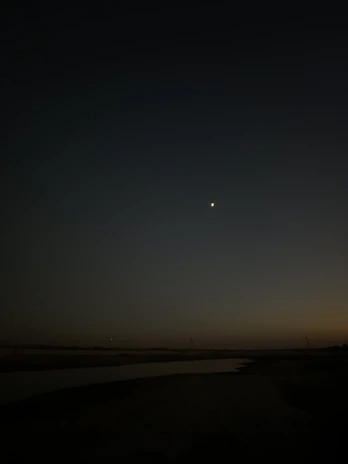 Evening scene of a luminous Helios V station softly illuminated under darkening blue sky.