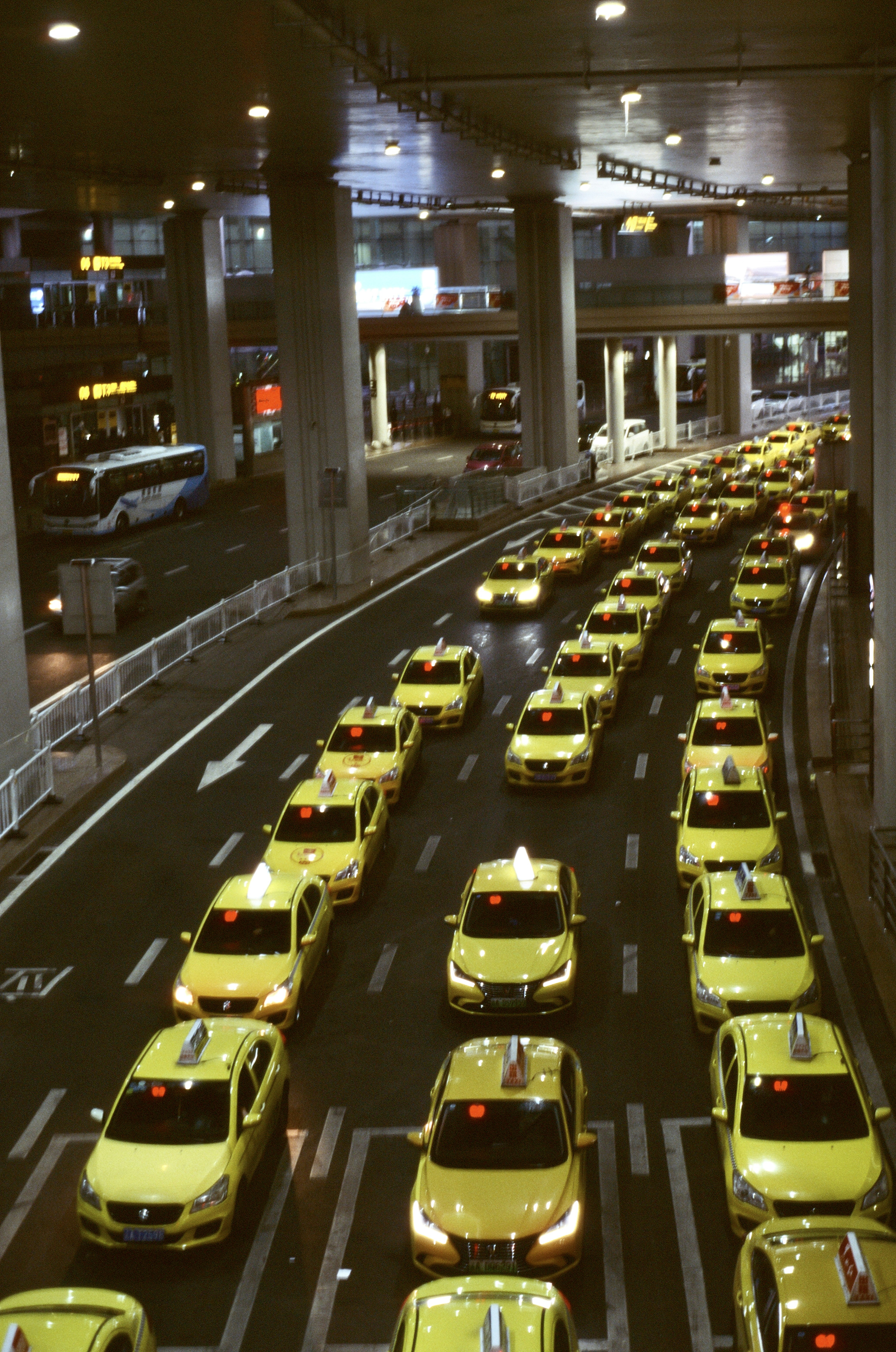 a lot of yellow taxis that are sitting in the street