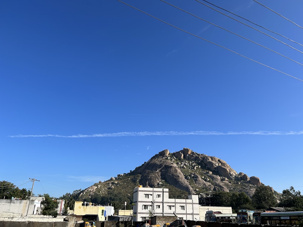 a large mountain in the distance with power lines in the foreground