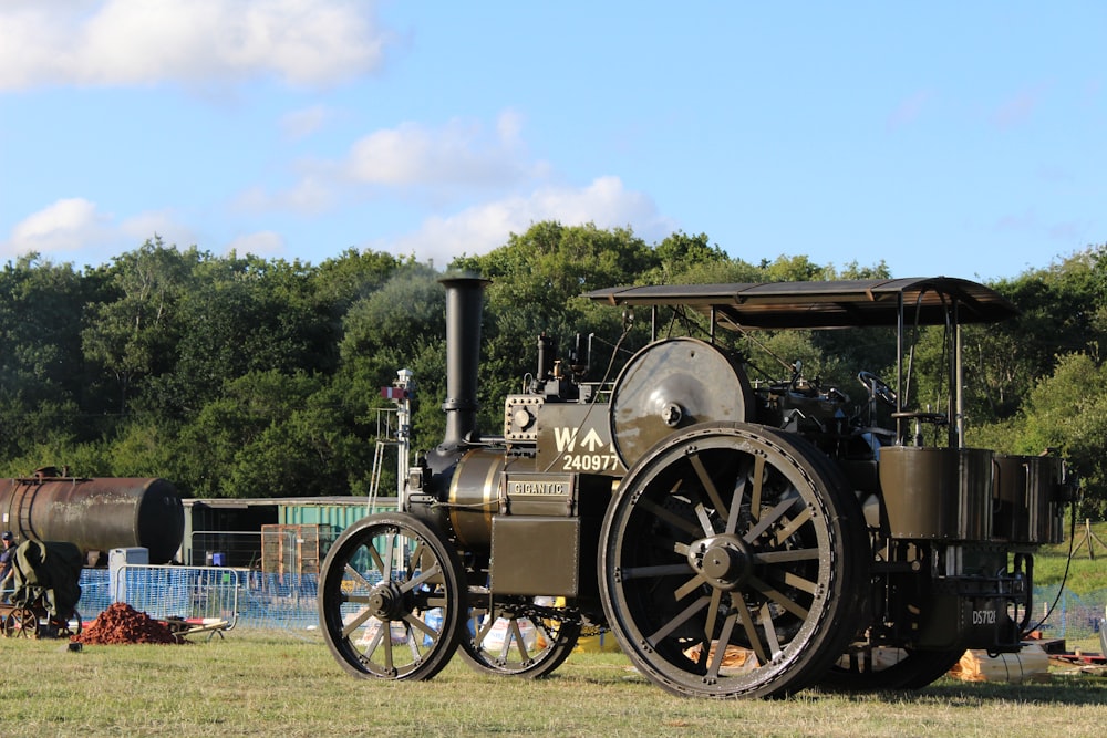 an old steam engine is parked in a field