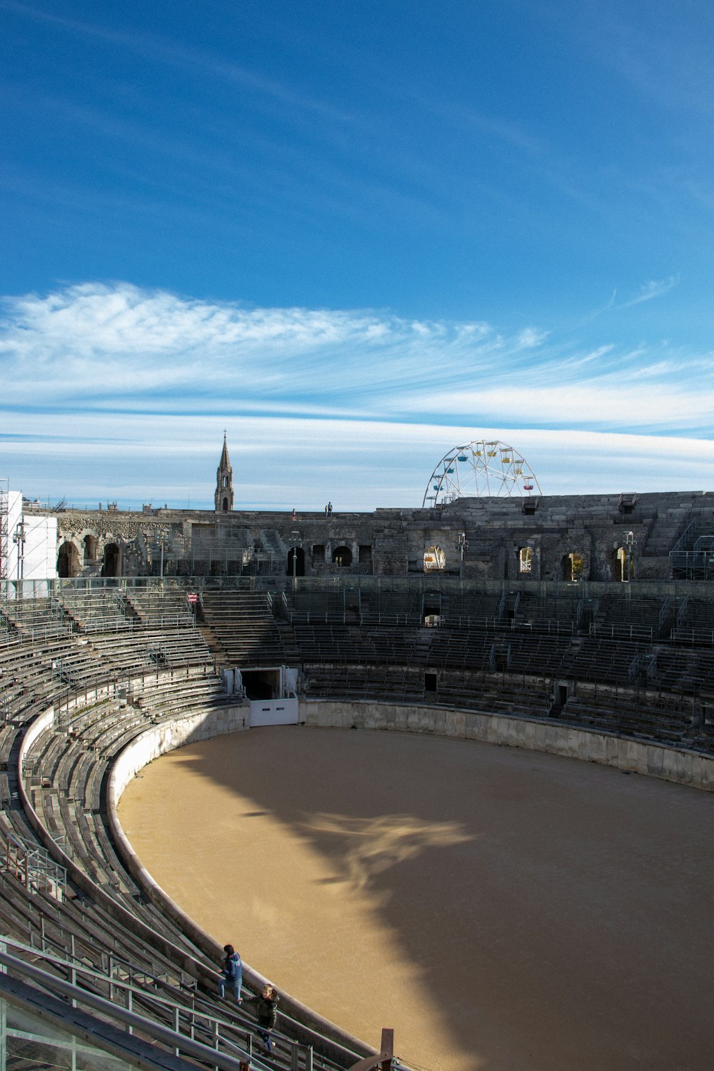 a large empty arena with a ferris wheel in the background