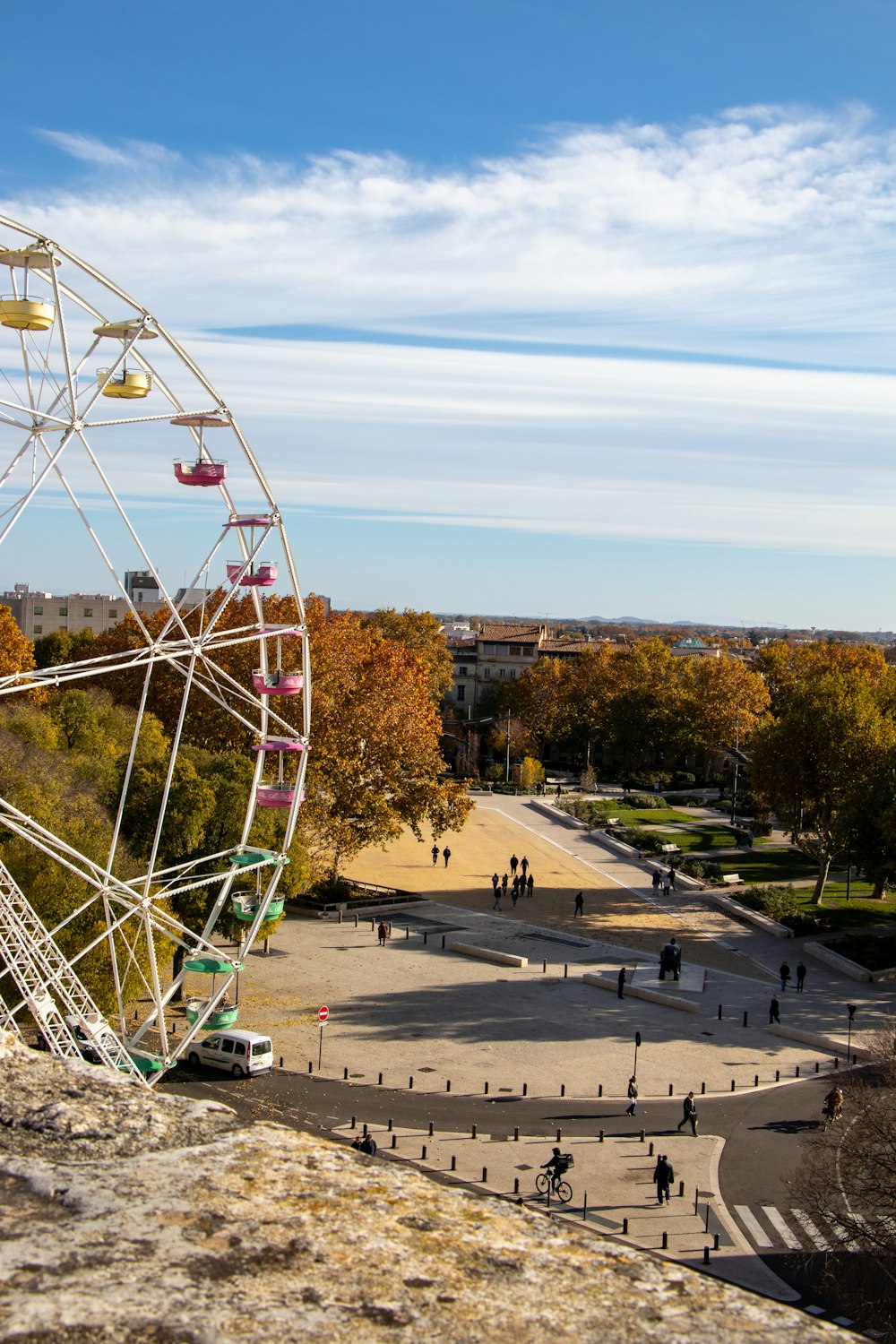 a ferris wheel sitting on top of a stone wall
