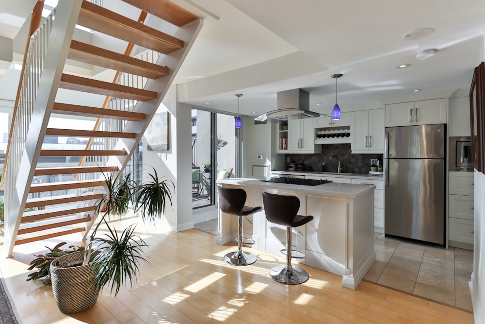 a kitchen with a staircase leading to the upper floor