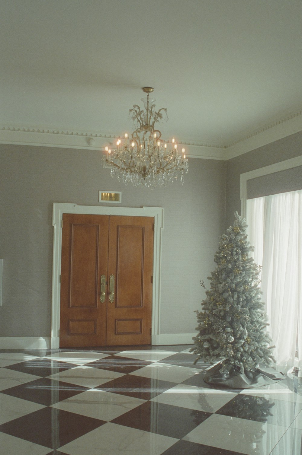 a christmas tree in a room with a chandelier