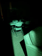 A creative team brainstorming ideas in a dark room illuminated by neon green lights.