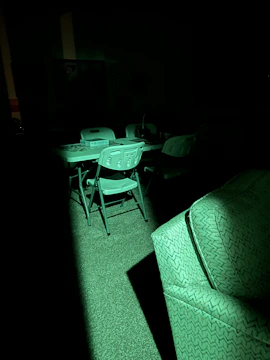 A creative team brainstorming ideas in a dark room illuminated by neon green lights.