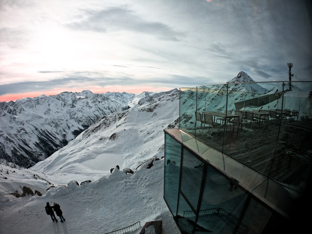 a couple of people standing on top of a snow covered slope