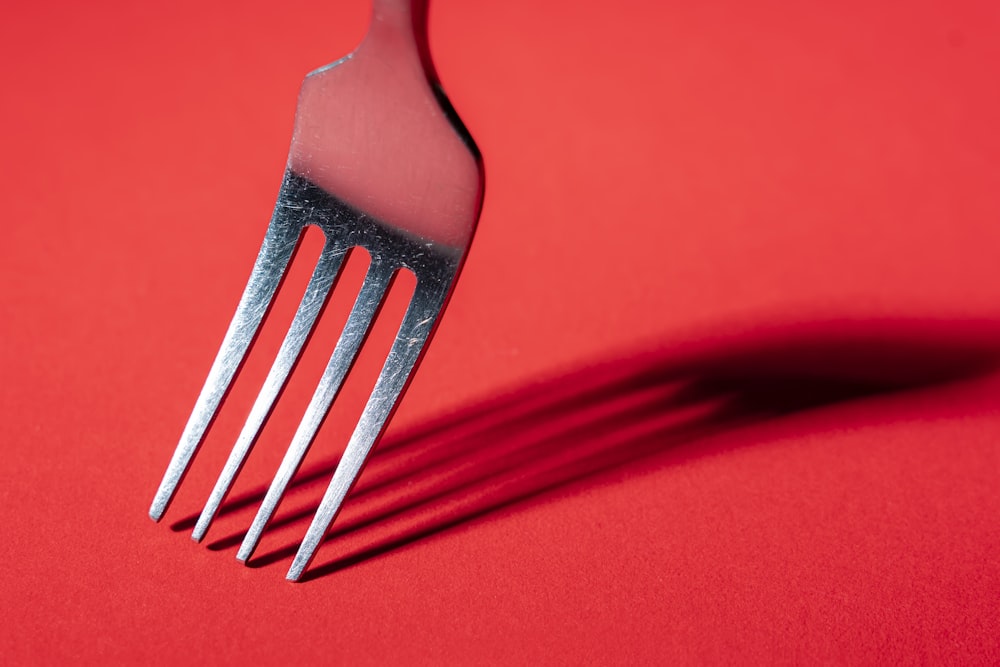 a fork with a red handle on a red surface