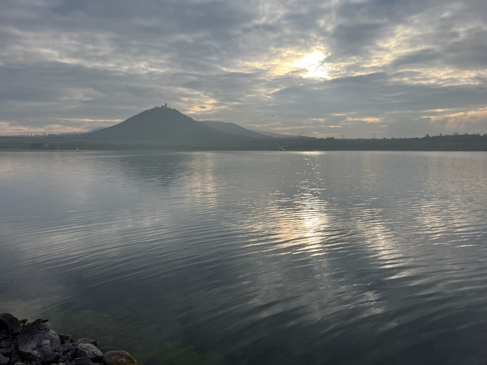 a large body of water with a mountain in the background