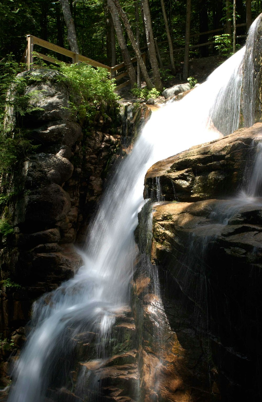 a waterfall with a wooden bridge over it