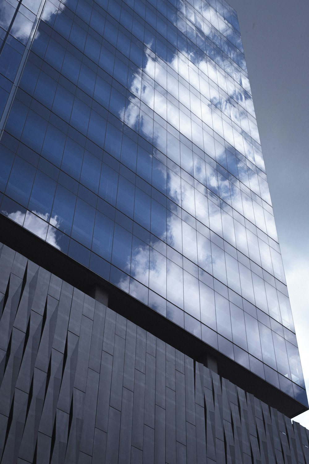 a tall building with a sky reflection in it