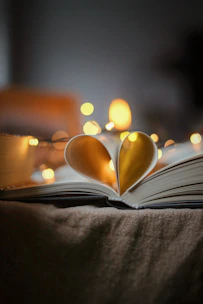 An open book with pages turning, surrounded by soft glowing fairy lights.