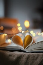an open book with a heart shaped pages