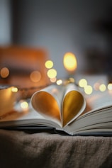 an open book with a heart shaped pages