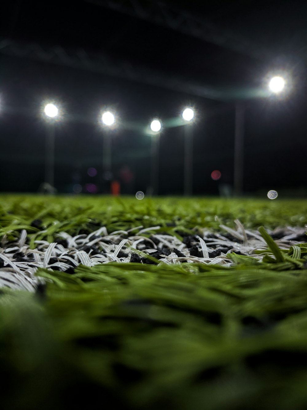 a soccer field covered in green grass at night