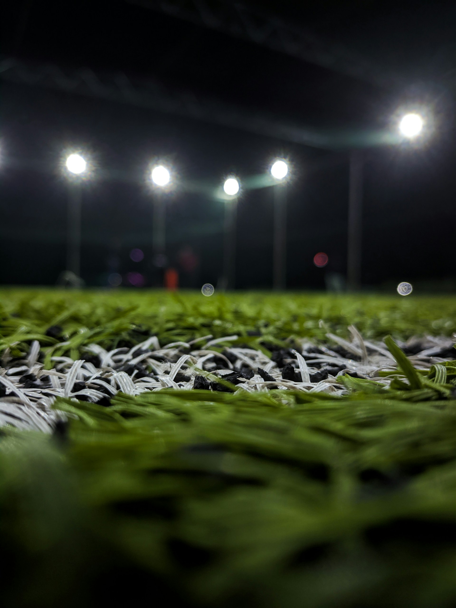 a soccer field covered in green grass at night