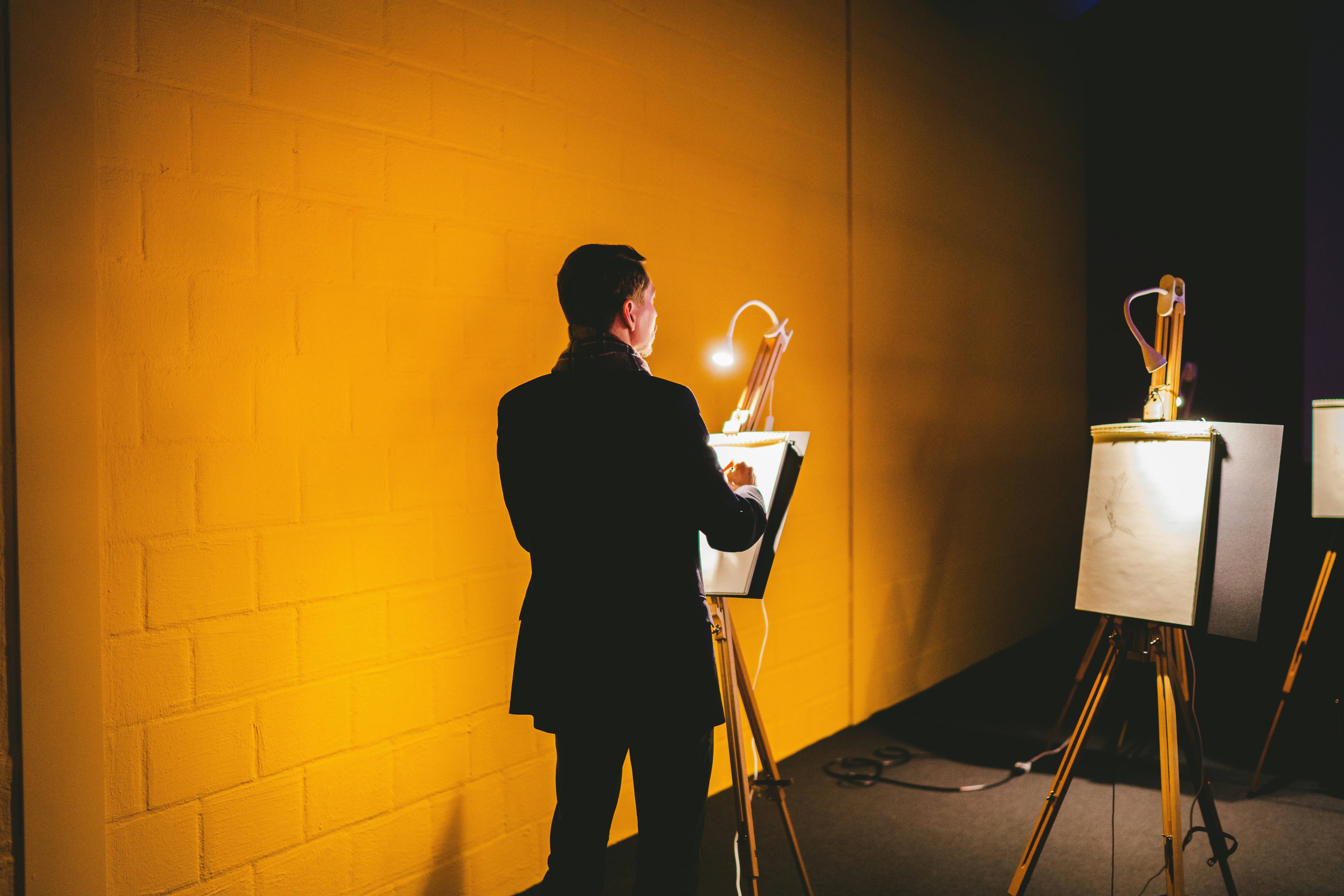 a man standing in front of a yellow wall