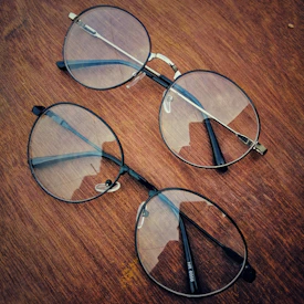 Close-up of elegant eyeglass frames displayed on a sleek wooden surface