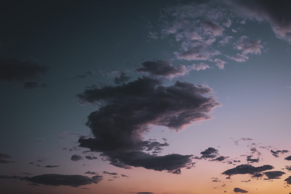 a plane flying in the sky at sunset