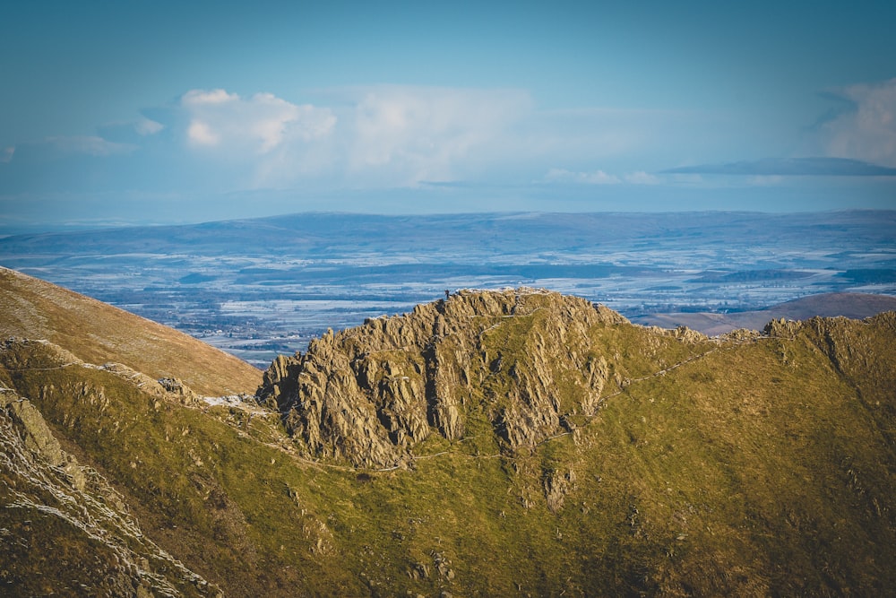 a view of a mountain range from the top of a hill