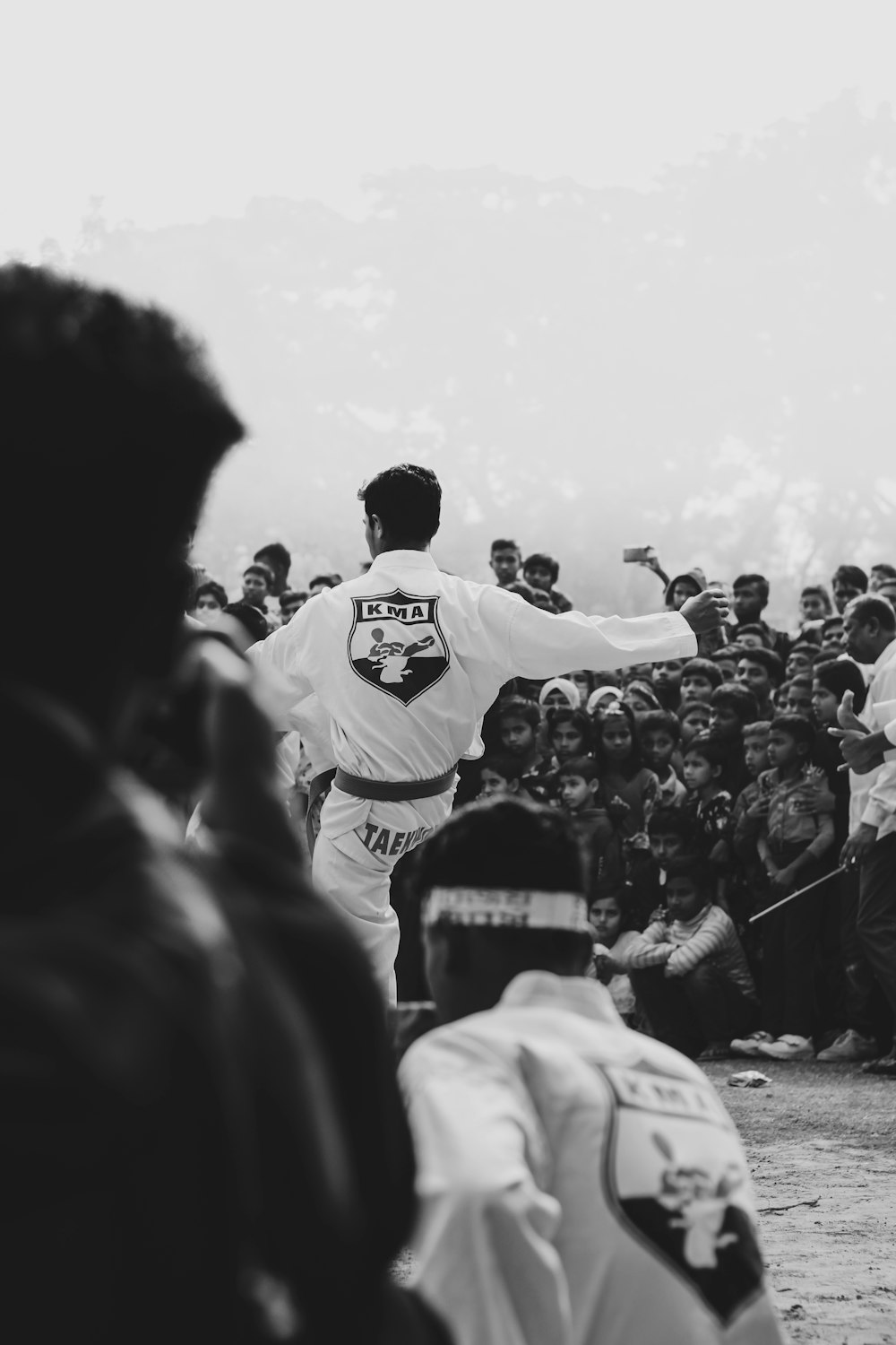 a group of people watching a man in a karate stance