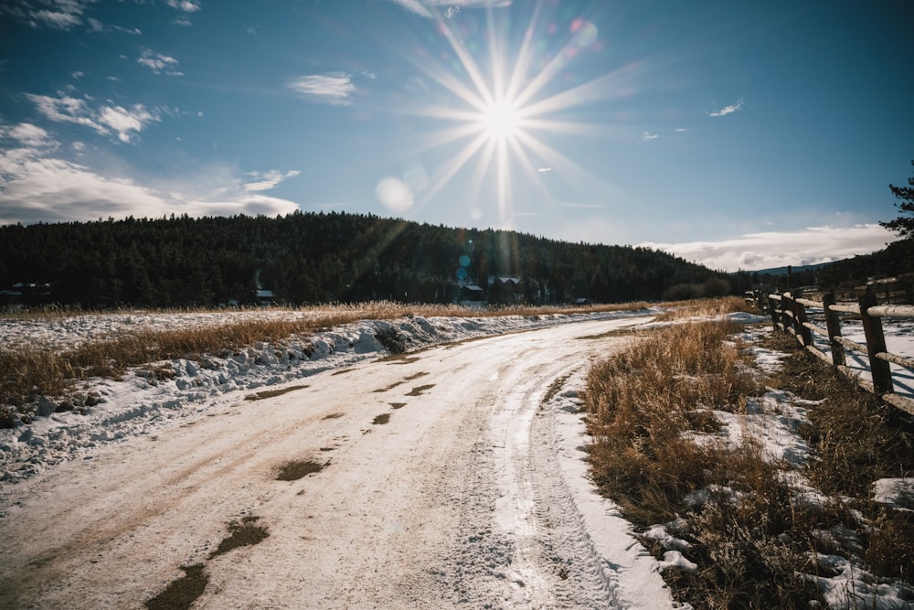 the sun shines brightly over a dirt road