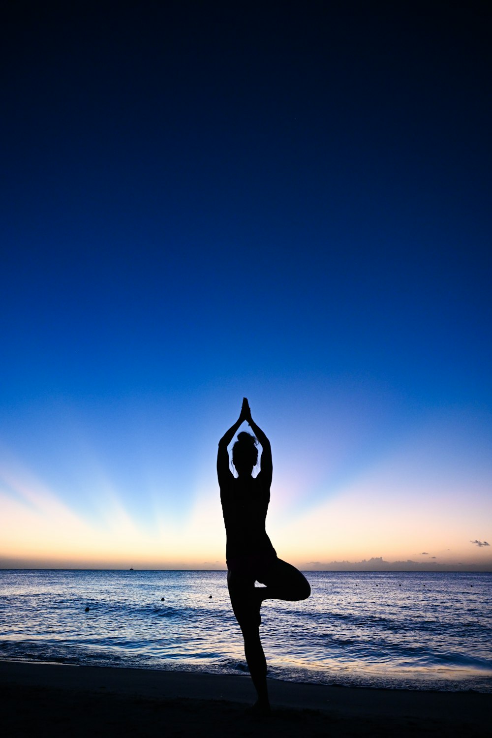 Eine Person, die Yoga am Strand bei Sonnenuntergang macht