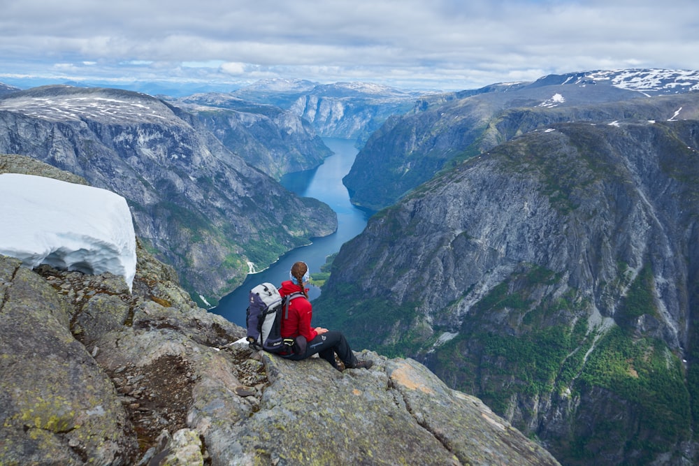 a couple of people sitting on top of a mountain