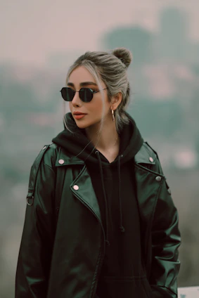Model wearing a black hoodie with subtle branding, standing against a minimalist urban backdrop