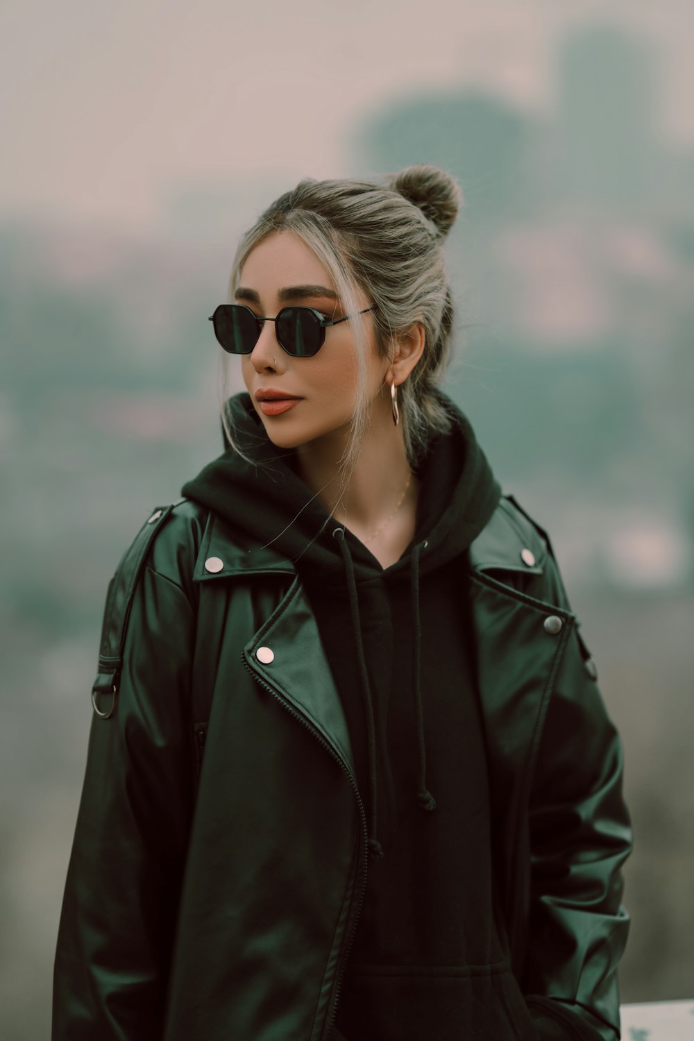 a woman wearing a black jacket and sunglasses